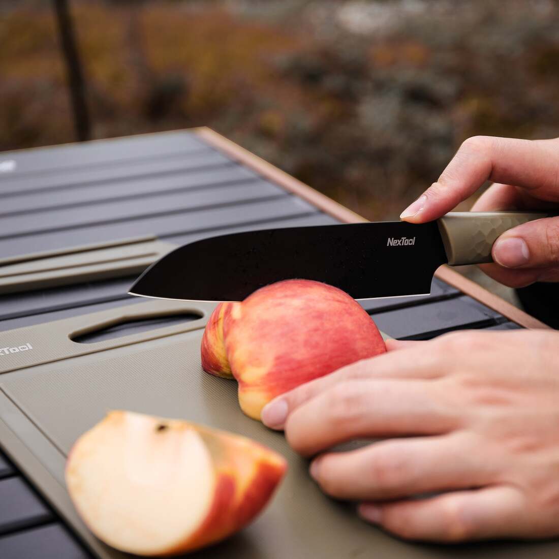 NexTool Santoku knife cutting fruit on the included board