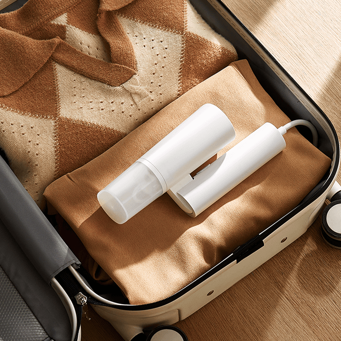Xiaomi handheld garment steamer folded for storage in a suitcase; shared manufacturer illustration