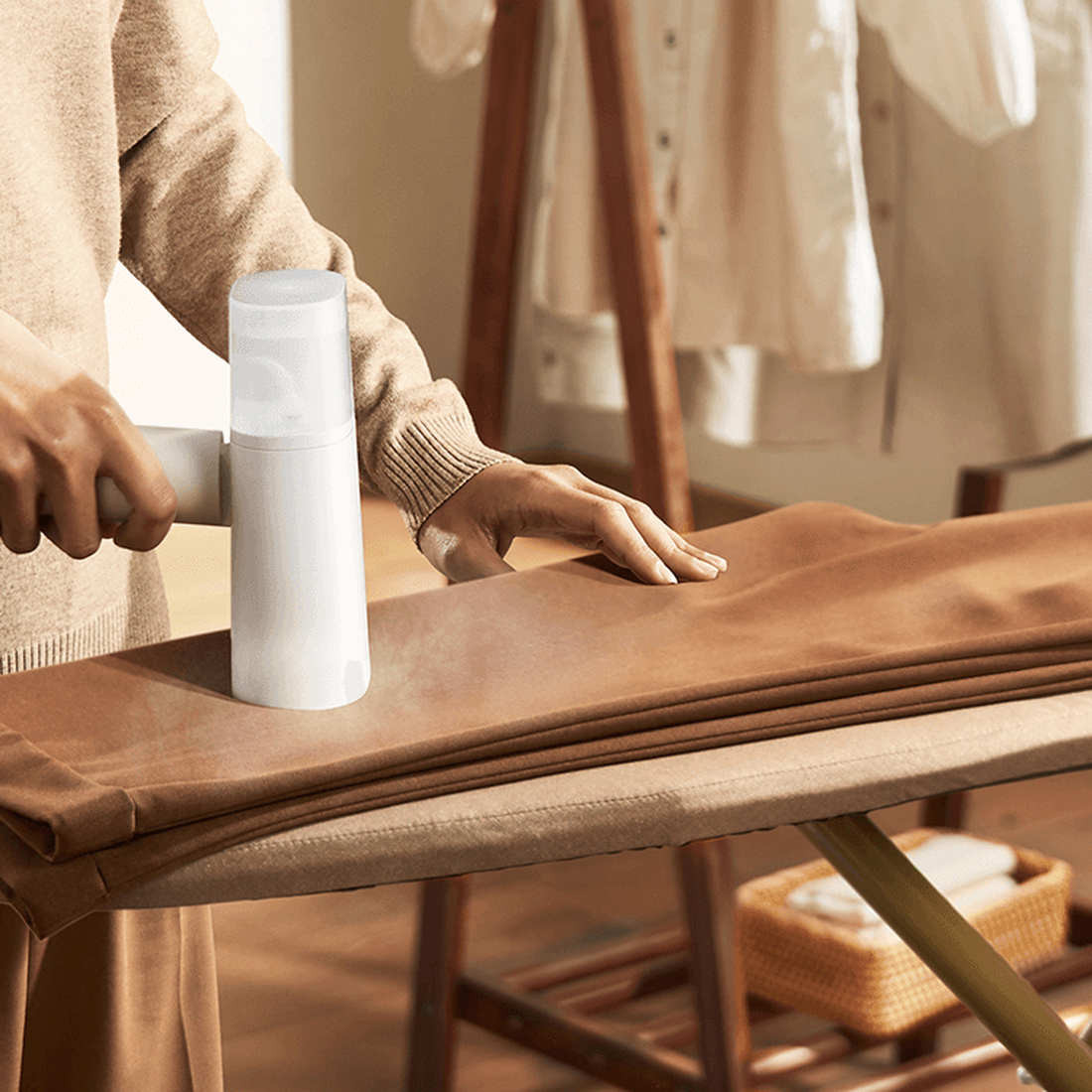 Xiaomi handheld garment steamer used horizontally on an ironing board; shared manufacturer illustration
