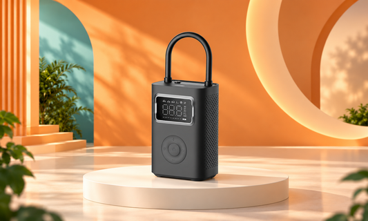 Xiaomi Portable Electric Air Compressor 2 Pro with its hose loop on a pedestal in an orange, peach and teal studio