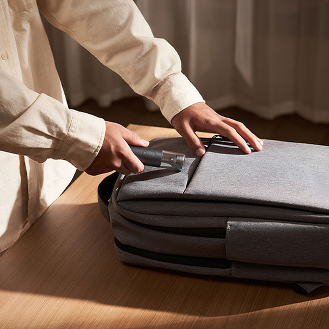 Mijia portable flashlight being placed in a bag; bag is a manufacturer illustration and not included