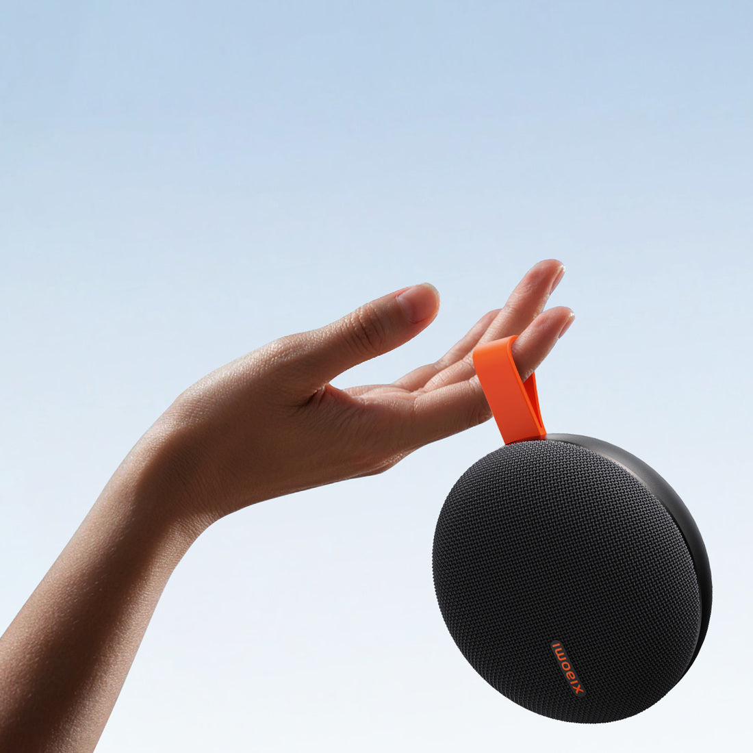 Black Xiaomi Bluetooth Speaker Essential carried by its orange loop