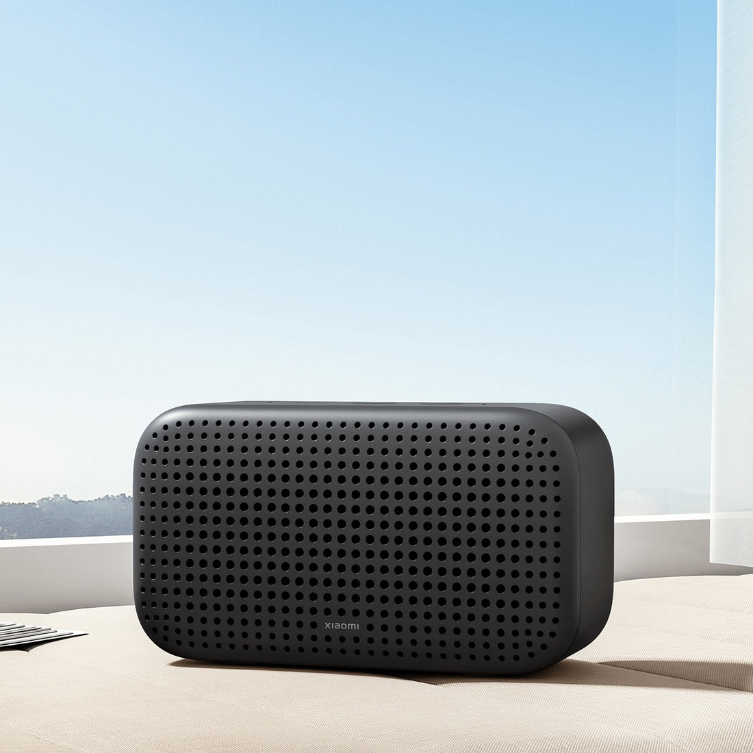 Xiaomi Smart Speaker Lite on a table beside a window